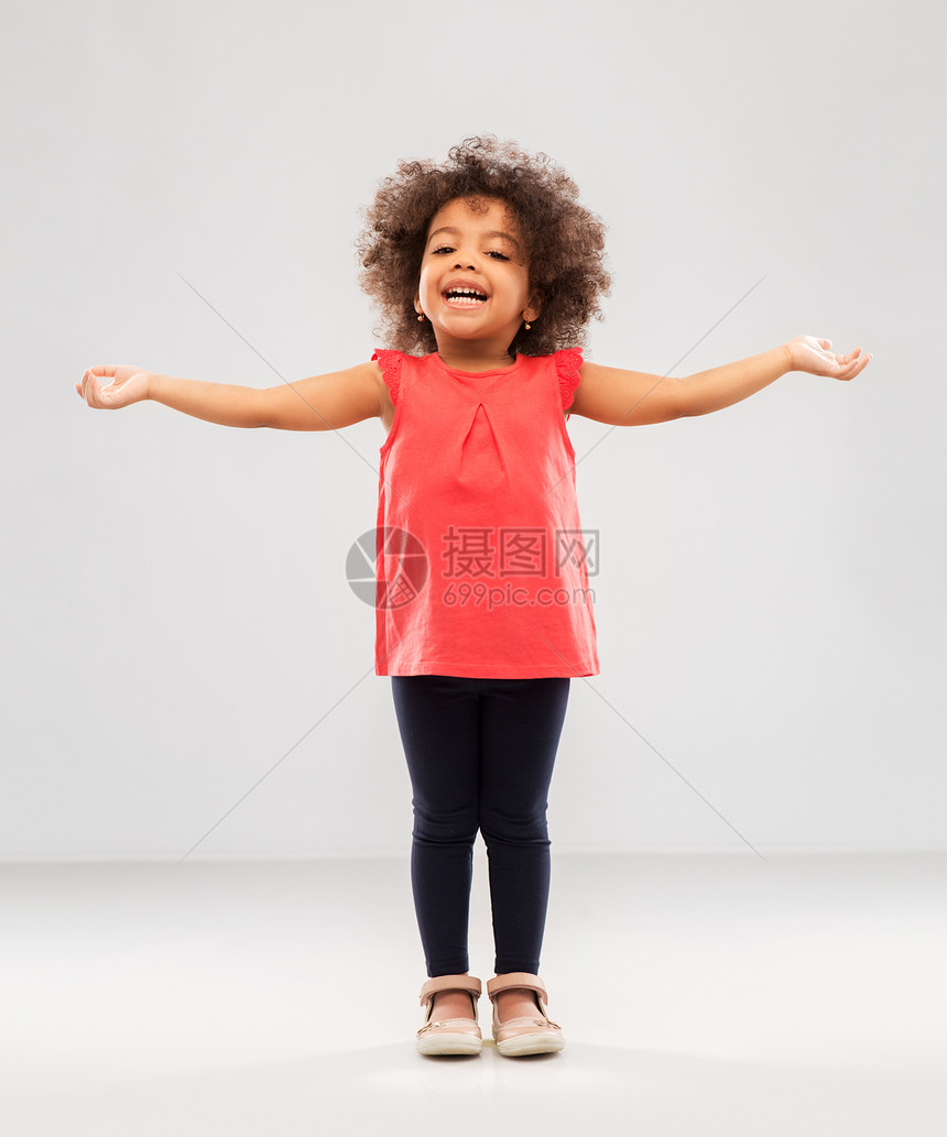 童人的快乐的非裔美国女孩与手臂分开的灰色背景快乐的小非裔美国女孩,手臂分开图片