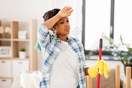 拖把头家务家务疲惫的非裔美国妇女家庭主妇,拖把清洁地板家里疲惫的非洲妇女家庭主妇家打扫卫生背景
