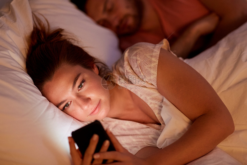男朋友正睡觉女人用智能手机图片