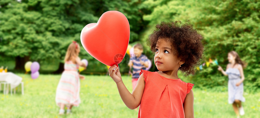童,表情情感快乐的非裔美国女孩与红色心形气球生日聚会夏季公园背景带心形气球的非裔美国女孩图片