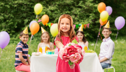 童人的快乐的红头发女孩与花的背景红头发的女孩生日聚会上带着花图片