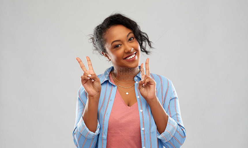 人手势快乐的非裔美国轻妇女粉红色的背景上展示平标志快乐的非裔美国妇女表现出平图片