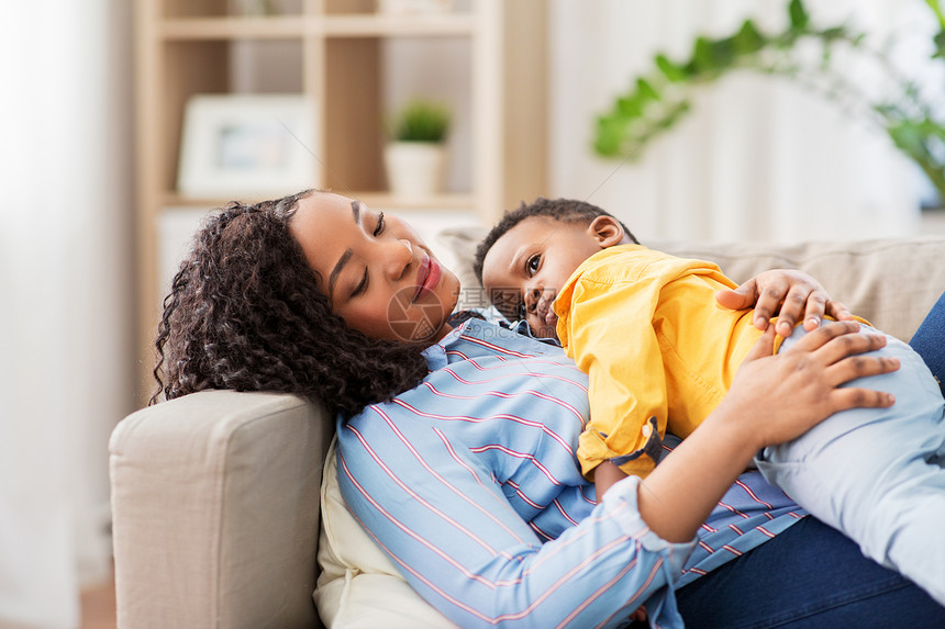 童,孩子人的快乐的非裔美国母亲她的小儿子躺沙发上家快乐的非裔美国母亲带着孩子家图片