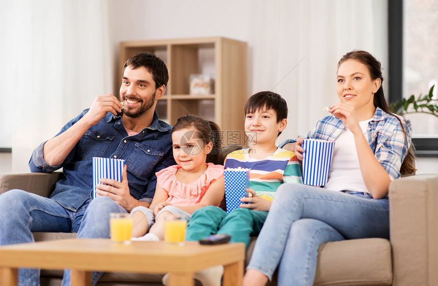 家庭休闲人的快乐的母亲父亲儿子女儿家里看爆米花家里爆米花看电视的幸福家庭图片