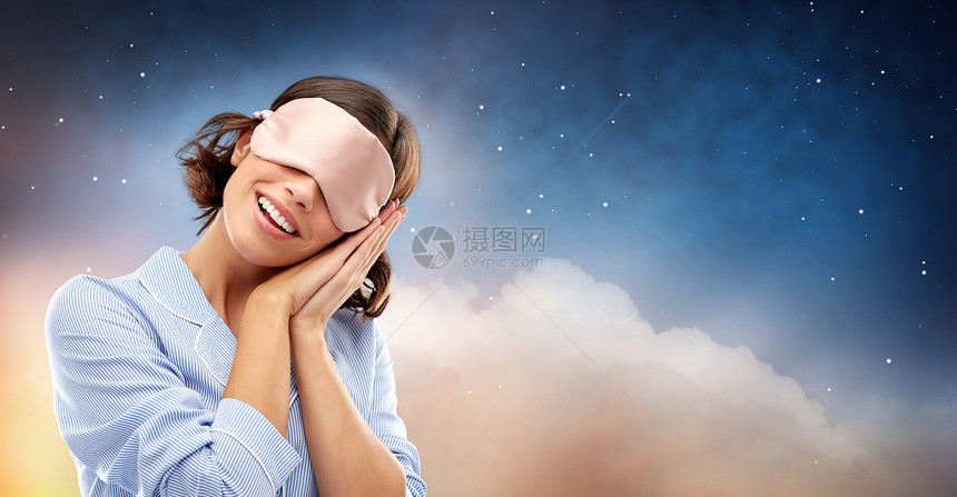 人们睡觉时间的快乐的轻女人睡衣眼罩星空云背景快乐的轻女人穿着睡衣眼罩图片