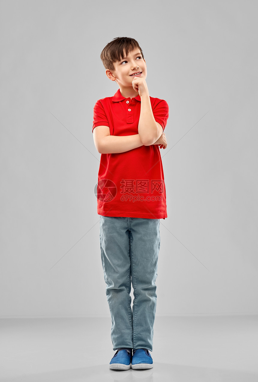 童,表情人的微笑的小男孩穿着红色马球T恤思考灰色背景穿着红色马球T恤的思考男孩图片