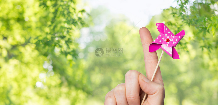 童,夏天身体部分的手握风车玩具绿色的自然背景手持风车玩具图片