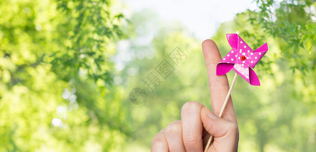 小齿轮人童,夏天身体部分的手握风车玩具绿色的自然背景手持风车玩具背景