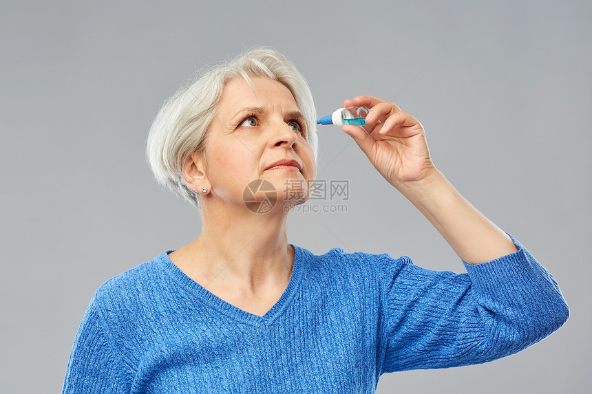 医学,健康视力人的老妇女干眼综合征的肖像用滴灰色背景上老妇女干眼综合征用滴剂图片