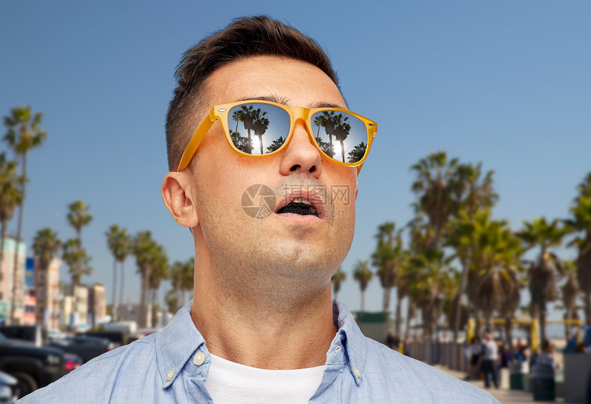 暑假,假期情感惊讶的中拉丁男子戴着太阳镜威尼斯海滩背景加利福尼亚威尼斯海滩上戴太阳镜的男人很惊讶图片