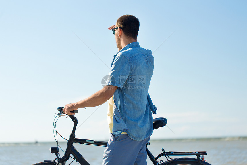 人们,休闲生活方式的快乐的轻人骑着自行车夏天的海滩上看着很远夏天海滩上骑自行车的人看着很远图片