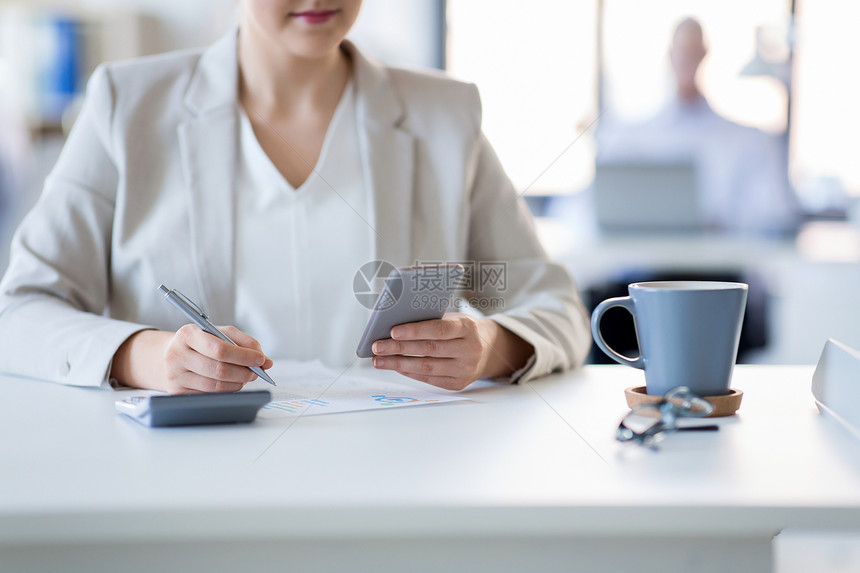 商业人的智能手机文件办公室工作的女商人智能手机的女商人办公室工作图片