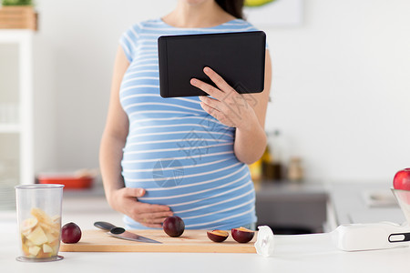 烹饪,怀孕技术孕妇与平板电脑,菜刀李子木制切割板家里孕妇家用平板电脑饭图片