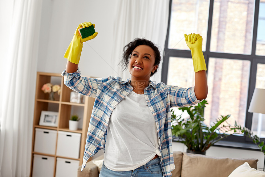 清洁,家务家务快乐的非裔美国妇女戴橡胶手套与海绵家快乐的非洲女人家里用海绵清洁图片