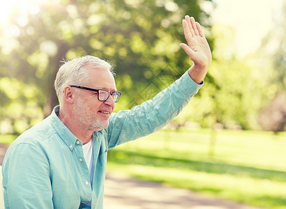 老,手势人的快乐的老人戴着眼镜夏季公园挥手快乐的老人夏天的公园挥手图片