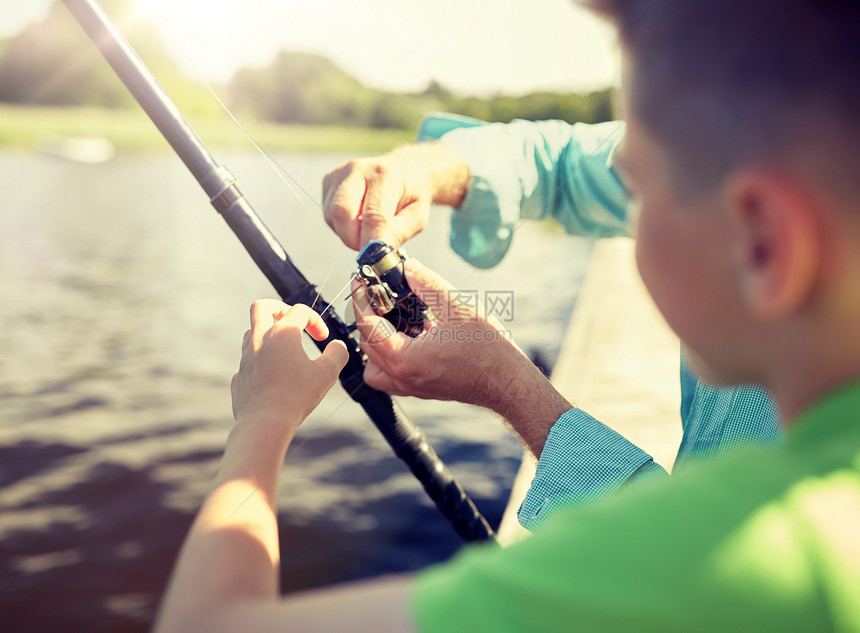 家庭,世代,暑假人的男孩祖父与鱼竿河流湖泊泊位男孩祖父河里钓鱼图片