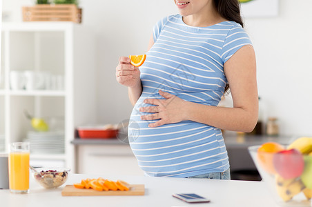 怀孕,健康食品人们的密切孕妇吃橙色早餐家里厨房孕妇家吃橘子图片