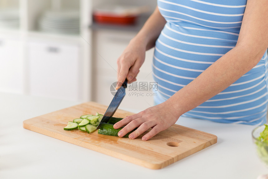 怀孕,烹饪食物健康饮食家里用菜刀切黄瓜孕妇家煮蔬菜沙拉图片