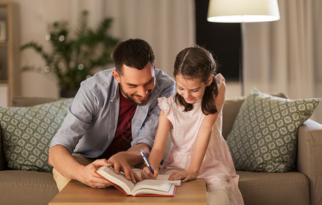教育,家庭家庭作业的快乐的父亲女儿家里写书笔记本父亲女儿作业图片