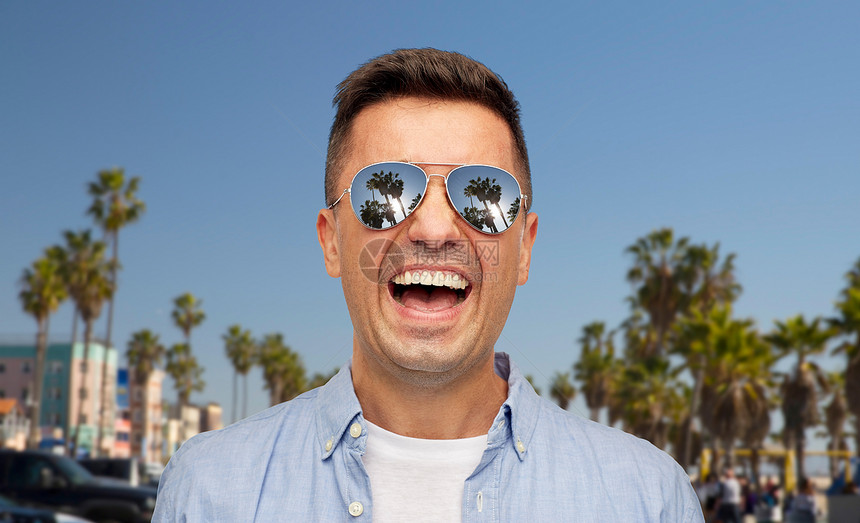 暑假,假期情感笑中拉丁男子穿着衬衫太阳镜威尼斯海滩背景加利福尼亚戴着太阳镜威尼斯海滩上笑的人图片