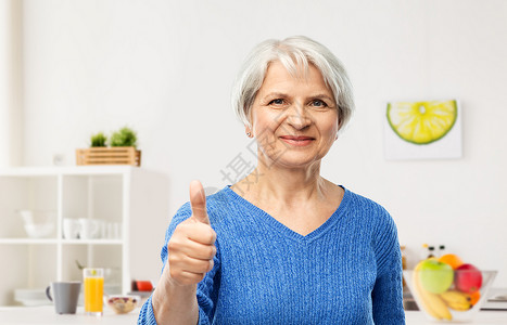 微笑的老年女性在厨房里竖大拇指图片