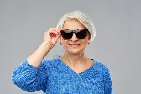 微笑的老年妇女戴着黑色太阳镜图片