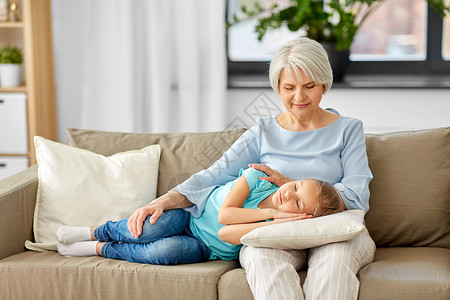 家庭世代人的快乐微笑的祖母孙女睡家里的枕头上祖母孙女睡枕头上图片