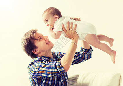 家庭,父亲父母的快乐微笑的轻父亲小婴儿家里快乐的轻父亲家里婴儿玩耍图片
