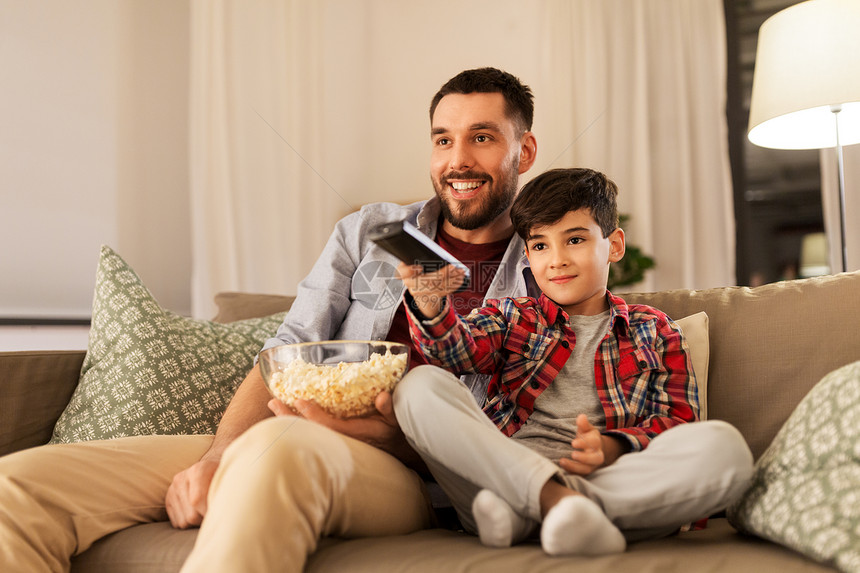 家庭,童,父亲,技术人的快乐的父亲小儿子带着爆米花遥控器家里晚上看电视父子带着爆米花家看电视图片