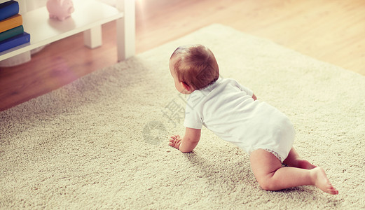 小婴儿家里地板上爬行背景图片
