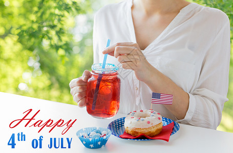 国防灾减灾日独立日,庆祝节日的7月4日的聚会上,绿色的自然背景下,用璃甜圈糖果果汁璃梅森罐杯子中妇女庆祝美国背景