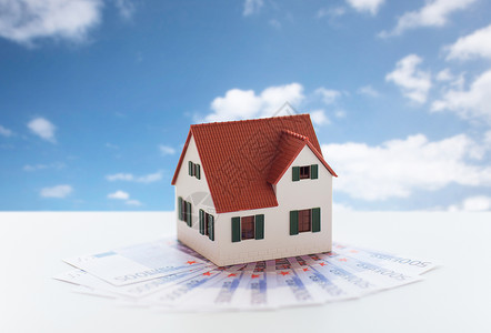 抵押贷款,房地产财产家庭房屋模型金钱蓝天云层背景家庭房屋模型金钱图片