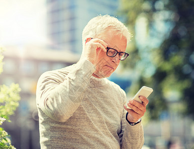 技术,人,生活方式沟通老人短信智能手机城市高级男子城市的智能手机上发短信图片
