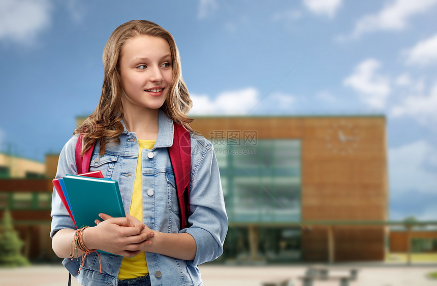 教育人的快乐微笑的十几岁的学生女孩带着书包书本学校背景下带着书包的快乐微笑的十几岁的学生女孩图片
