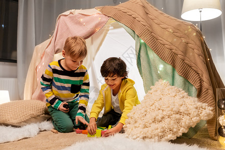 舒适度小的童,潮湿友谊的男孩玩玩具块孩子帐篷帐篷家里男孩家孩子们的帐篷里玩玩具块背景