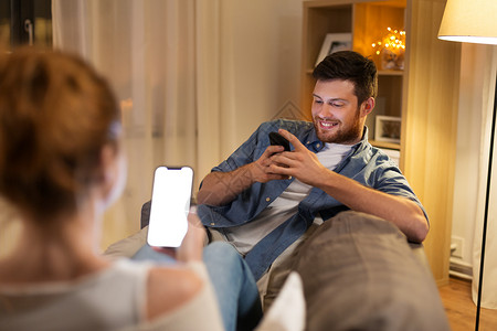 休闲,技术网络成瘾的夫妇家里的智能手机晚上晚上家里智能手机的夫妇图片