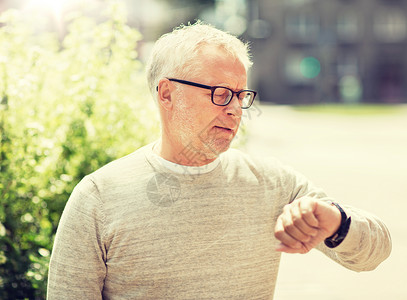 准时人的老人检查时间他的手表智能手表城市老人手表上检查时间图片