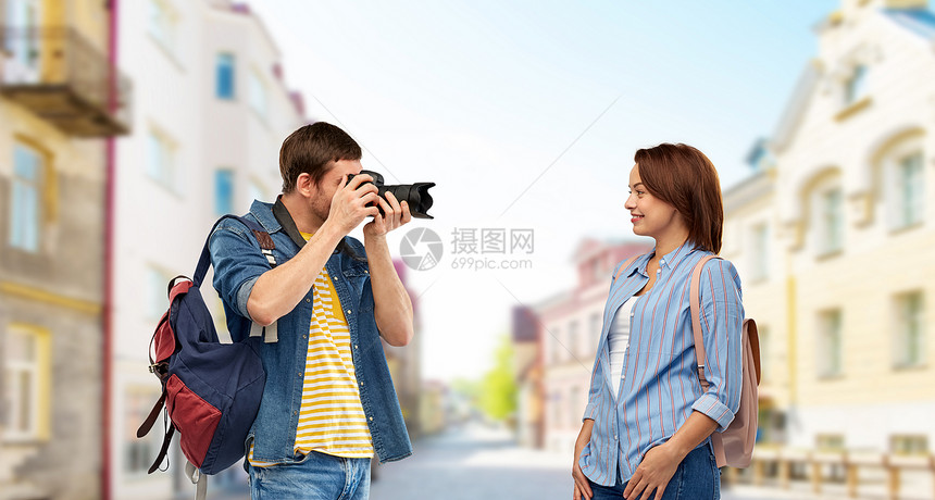 旅行,旅游度假的快乐的游客带着背包相机塔林市背景的老镇街上拍照带背包照相机的快乐游客图片