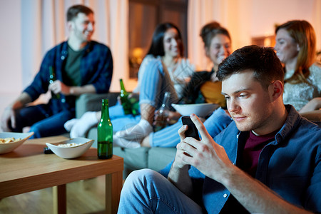 技术,网络成瘾人的男人与智能手机家里朋友聚会晚上家里智能手机的男人图片