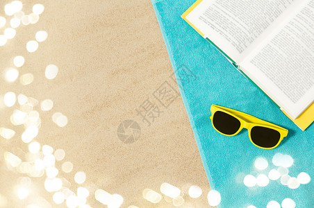 假期,旅行暑假的黄色太阳镜预订蓝色沙滩毛巾沙子上太阳镜沙滩毛巾上的书图片