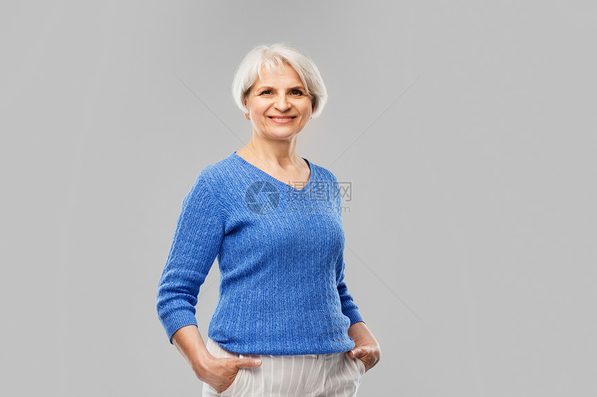 灰色背景下微笑的老年女性图片