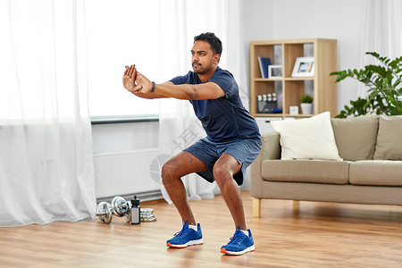 运动健康的生活方式印度男子与健身跟踪运动蹲家印度男人家锻炼蹲图片
