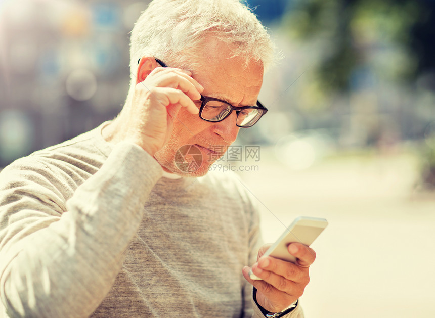 技术,人,生活方式沟通老人短信智能手机城市高级男子城市的智能手机上发短信图片