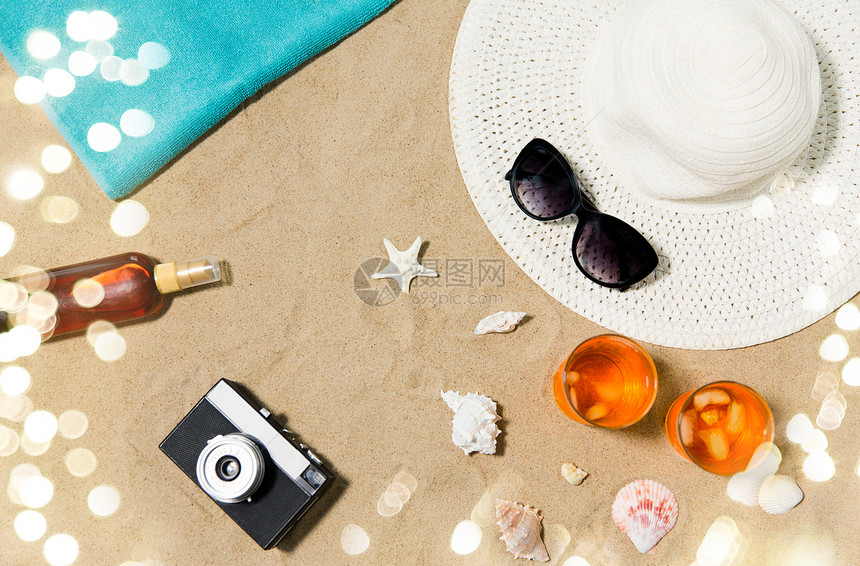 假期,旅行夏季两杯开胃酒鸡尾酒与冰,太阳帽与太阳镜,老式胶卷相机与防晒霜油贝壳海滩沙滩海滩沙滩上的饮料帽子照图片