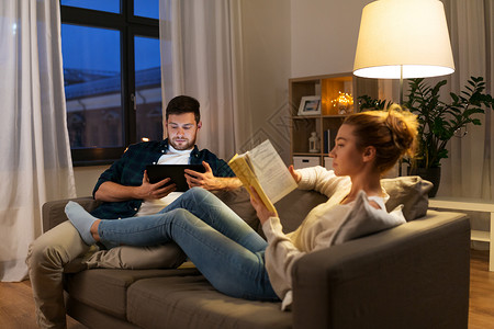 休闲人们的快乐的夫妇与平板电脑书籍家里晚上家里平板电脑书图片