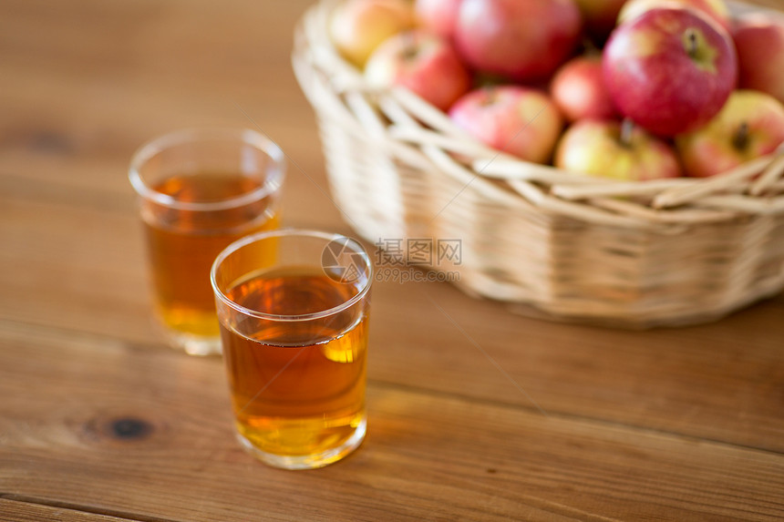 水果食物收获的柳条篮子里的苹果木桌上的杯果汁篮子里的苹果桌子上的杯果汁图片