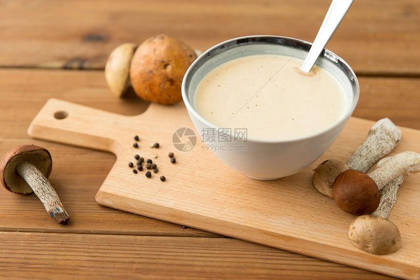 食物烹饪,饮食烹饪蘑菇奶油汤碗木制切割板切板上碗里的蘑菇奶油汤图片