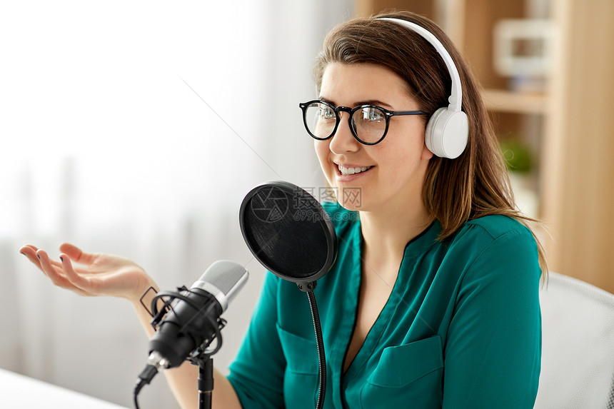 技术,大众媒体人们的戴着麦克风耳机的眼镜的女人录音室交谈录制播客演播室里麦克风录音播客的女人图片