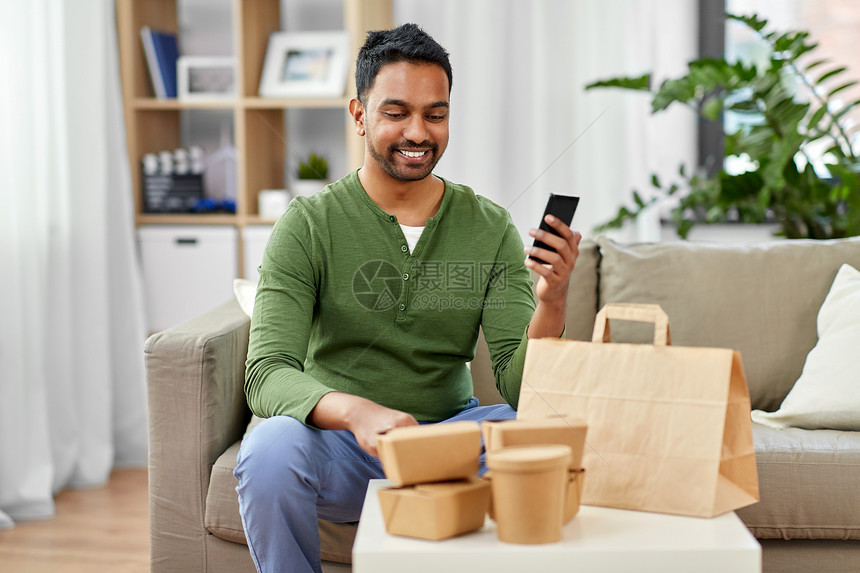 技术,消费人的微笑的印度男子用智能手机家里提供食物印度男人用智能手机送食物图片