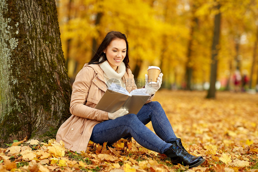 季节,技术人的轻的女人阅读书籍喝外卖咖啡纸杯秋季公园秋天公园里的女人用咖啡读书图片